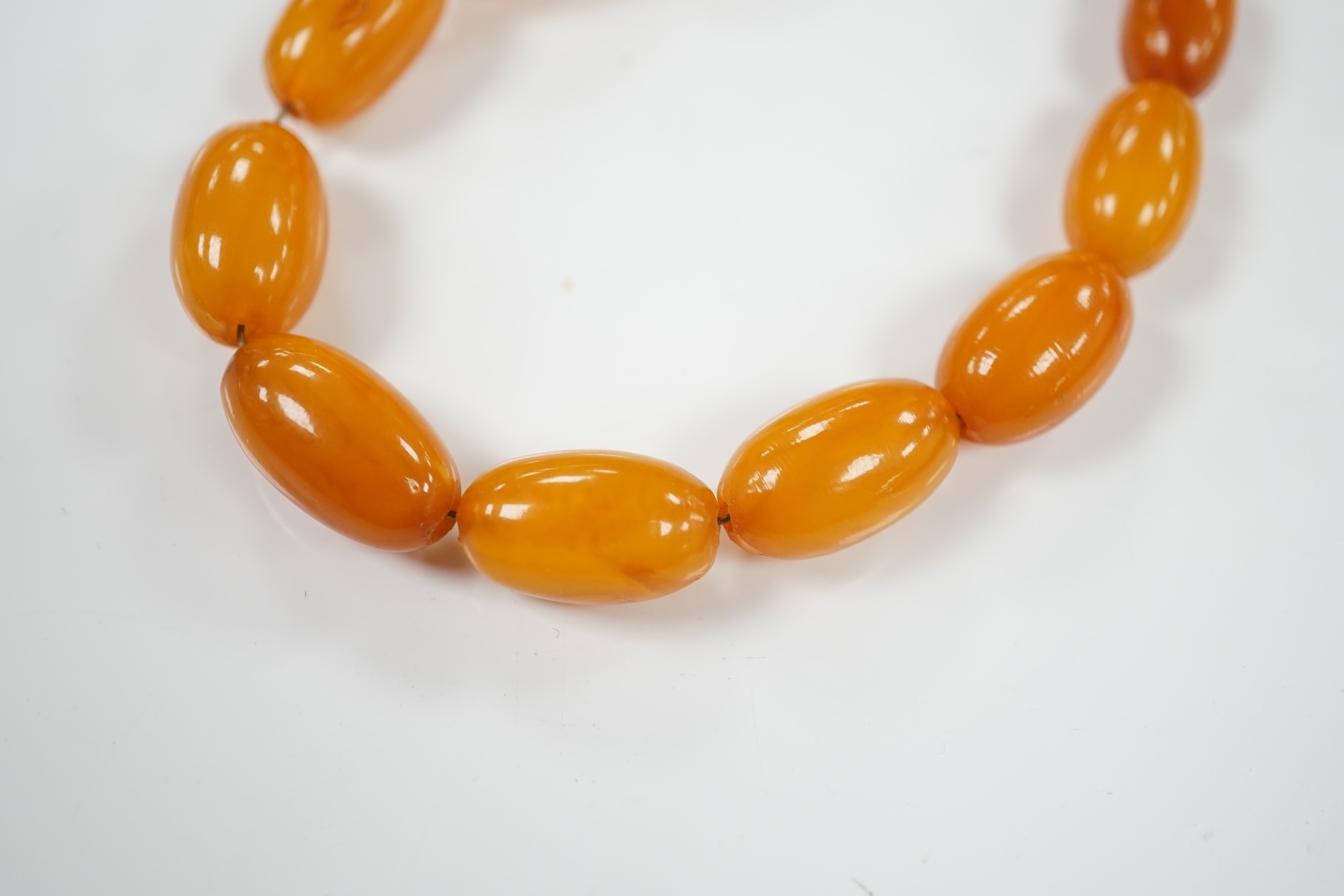 A single strand graduated amber bead necklace, 66cm, gross weight 40 grams. Condition - poor to fair